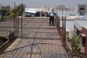 Pastor Joseph inspects the second concrete slab as work continues on Pune Center.