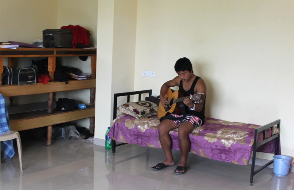 Student playing guitar in KSOM dorm